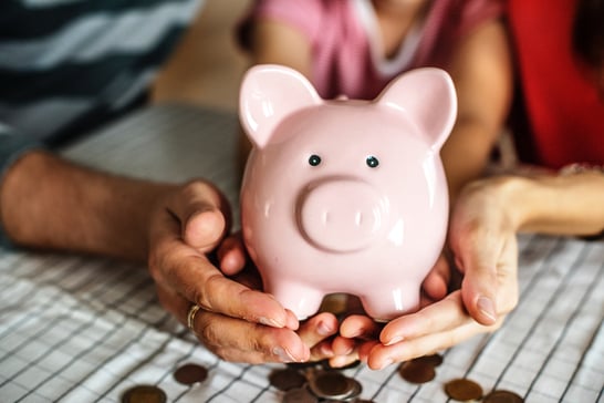 two people holding piggy bank with coins