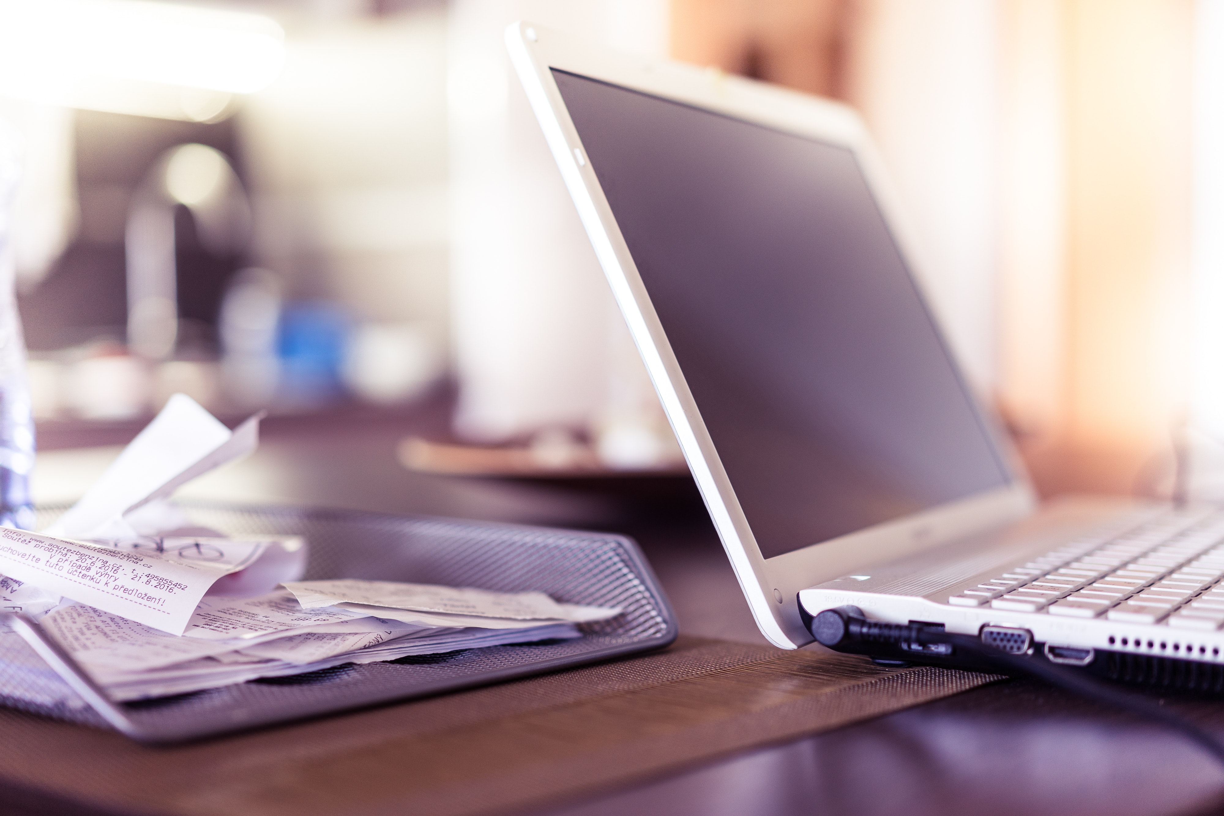 laptop computer on desk with receipts